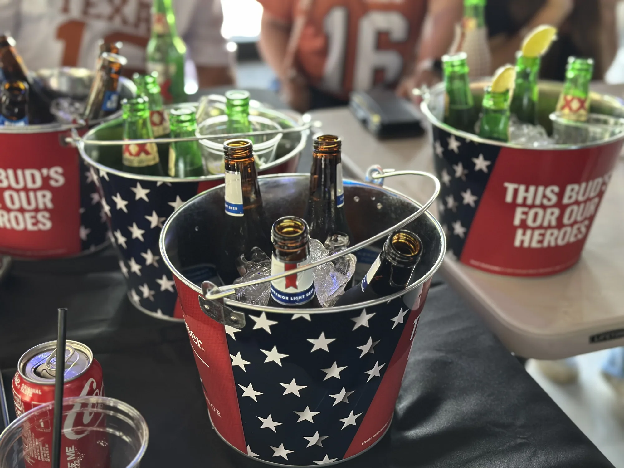Stars-and-stripes buckets packed with ice and bottles of beer on the bar